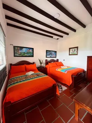 two beds in a room with orange sheets at Loft Terraza Jericó in Jericó