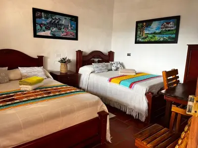 a bedroom with two beds and a table and a desk at Loft Terraza Jericó in Jericó
