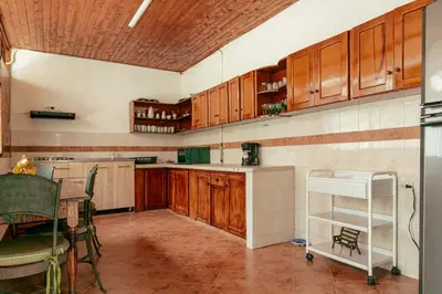 a kitchen with wooden cabinets and a table and a counter at LUzArt in Jardin