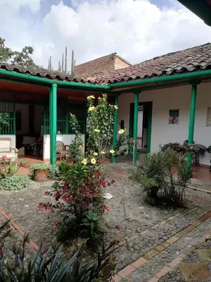 a house with green columns and a courtyard at LUzArt in Jardin