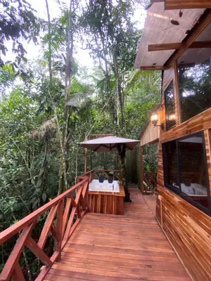 a wooden walkway to a house in the woods at ECO HOTEL RIO DE ORO in San Rafael