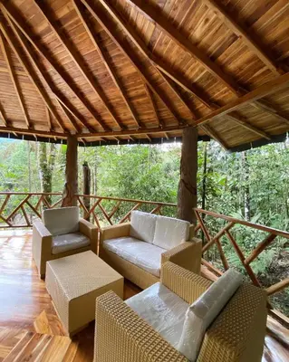 a porch with couches and chairs on a deck at ECO HOTEL RIO DE ORO in San Rafael