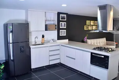 a kitchen with white cabinets and a black refrigerator at Espectacular apt 3 habitaciones deluxe! in Envigado