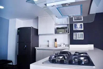 a kitchen with a black refrigerator and white cabinets at Espectacular apt 3 habitaciones deluxe! in Envigado