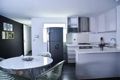 a kitchen with a refrigerator and a table and chairs at Apartamento de 3 habitaciones con jacuzzi deluxe! in Envigado