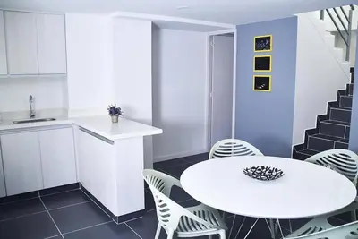 a white kitchen with a white table and chairs at Apartamento de 3 habitaciones con jacuzzi deluxe! in Envigado