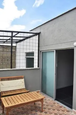 a wooden bench sitting on a patio next to a building at Apartamento de 3 habitaciones con jacuzzi deluxe! in Envigado