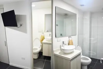 a bathroom with two toilets and a sink and mirror at Espectacular apt de 3 habitaciones deluxe! in Envigado