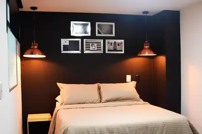 a bedroom with a black wall with a bed and two lights at Espectacular apt de 3 habitaciones deluxe! in Envigado