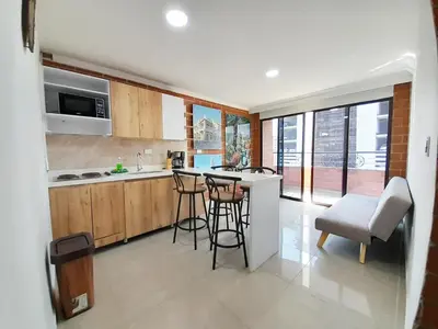 a kitchen with a counter and some stools in it at Precioso apartamento en Medellín con parqueadero gratis laure in Medellín