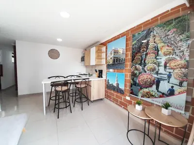 a kitchen with stools and a mural on the wall at Precioso apartamento en Medellín con parqueadero gratis laure in Medellín