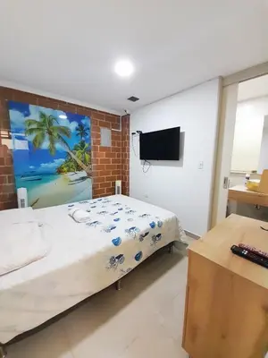 a bedroom with a large bed and a flat screen tv at Precioso apartamento en Medellín con parqueadero gratis laure in Medellín