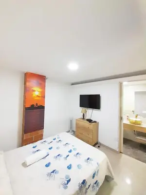 a bedroom with a bed and a bathroom with a sink at Precioso apartamento en Medellín con parqueadero gratis laure in Medellín
