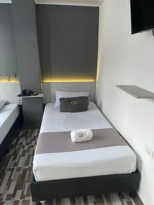 a small bedroom with two beds in a room at Hotel Pass, Laureles Medellín in Medellín