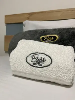 a white towel sitting on top of a bed at Hotel Pass, Laureles Medellín in Medellín