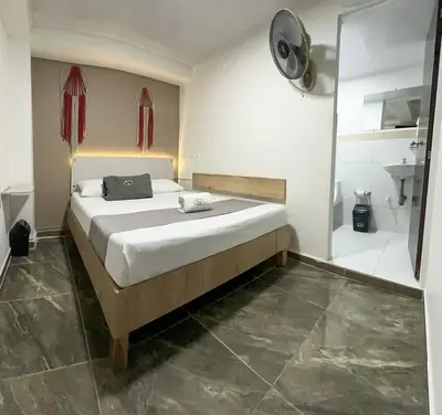 a bedroom with a large bed and a shower at Hotel Pass, Laureles Medellín in Medellín