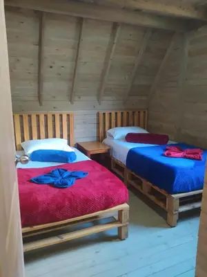 two beds in a room with wooden walls at Chalet de Liz - Guatapé in Guatapé