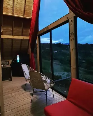 a room with two chairs and a large window at Chalet de Liz - Guatapé in Guatapé