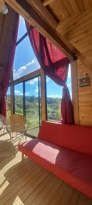 a bed in a room with a large window at Chalet de Liz - Guatapé in Guatapé