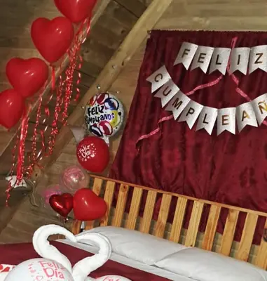 a bed with red hearts and a sign with the words happy anniversary at Chalet de Liz - Guatapé in Guatapé