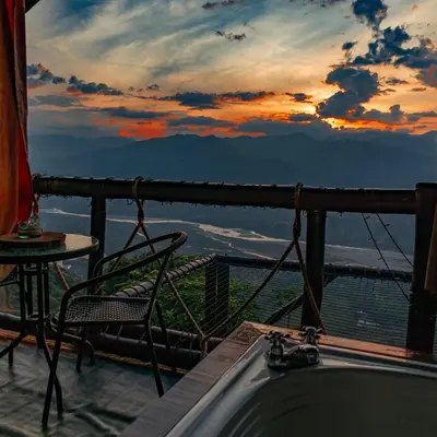 a bath tub sitting on top of a balcony with a sunset at Glamping Mirador Santa Fe-Sopetran in Sopetran