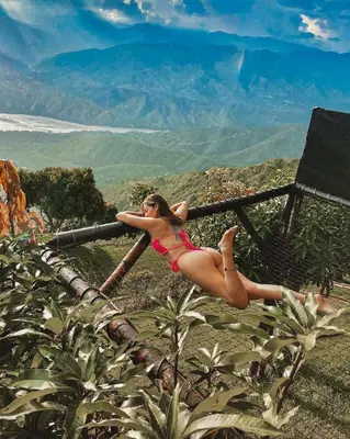 a woman in a red bikini laying on a pole at Glamping Mirador Santa Fe-Sopetran in Sopetran