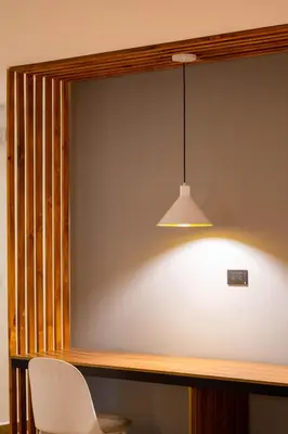 a table with a white chair and a light at Hotel California City in Medellín