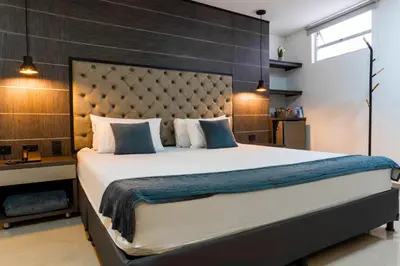 a bedroom with a large bed with a large headboard at Hotel California City in Medellín
