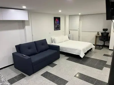 a bedroom with a bed and a blue couch at Puesta de Sol El Carmen de Viboral in Carmen de Viboral