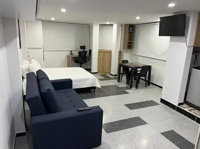 a bedroom with a bed and a couch and a table at Puesta de Sol El Carmen de Viboral in Carmen de Viboral