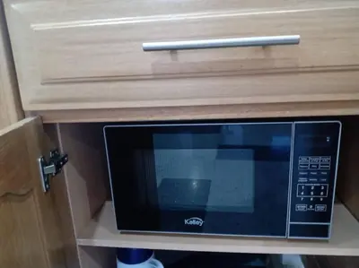 a microwave in a wooden cabinet with a drawer at Puesta de Sol El Carmen de Viboral in Carmen de Viboral