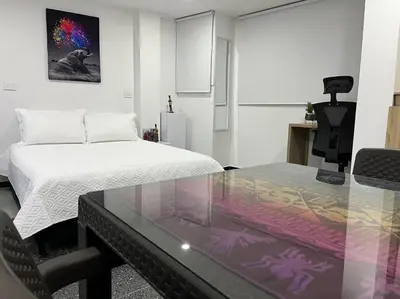 a room with a bed and a glass table at Puesta de Sol El Carmen de Viboral in Carmen de Viboral
