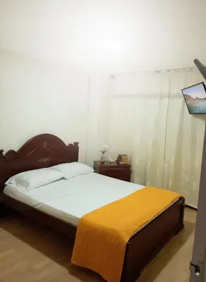 a bedroom with a bed with a yellow blanket on it at Fuera de Casa como en Casa in Manizales
