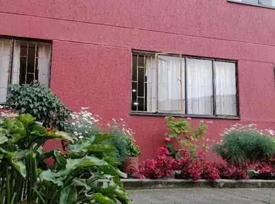 a pink building with flowers in front of it at Fuera de Casa como en Casa in Manizales