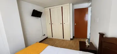 a bedroom with a bed and a television on the wall at Fuera de Casa como en Casa in Manizales