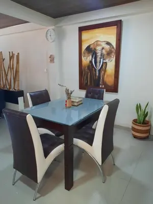 a dining room table with chairs and a painting of an elephant at Casa central, segundo piso in Norcasia