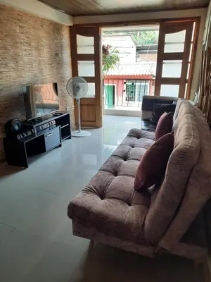 a living room with a couch and a tv at Casa central, segundo piso in Norcasia