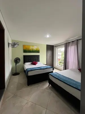 a bedroom with two beds and a window at Amoblado laureles San Joaquín in Medellín