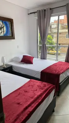 two beds in a room with a window at Amoblado laureles San Joaquín in Medellín
