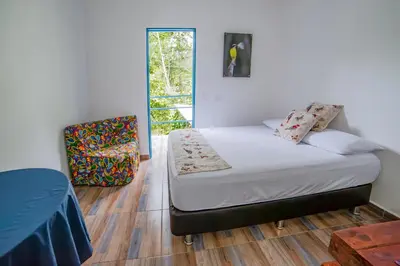 a bedroom with a bed and a chair at La Posada de las Aves in San Rafael