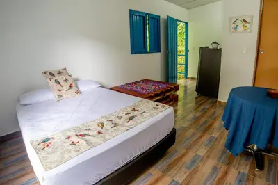 a bedroom with a bed and a blue table at La Posada de las Aves in San Rafael