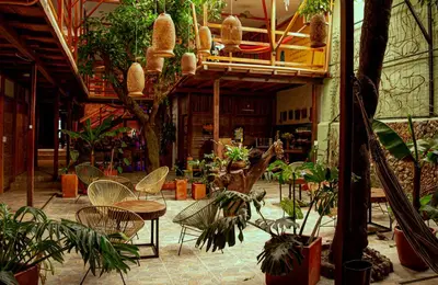 a patio with tables and chairs and plants at Refugio del Jaguar in Medellín