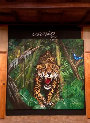 a painting of a jaguar in the jungle at Refugio del Jaguar in Medellín