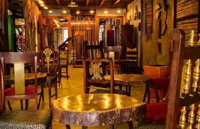 a room with chairs and tables and a table with a stump stumpasteryasteryastery at Refugio del Jaguar in Medellín
