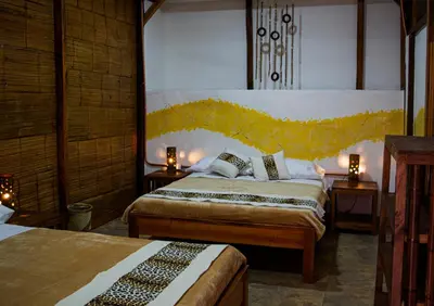a bedroom with two beds and two tables with lamps at Refugio del Jaguar in Medellín