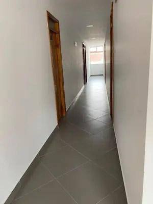 a hallway with white walls and a tile floor at HOTEL GRAN PLAZA SAN RAFAEL in San Rafael