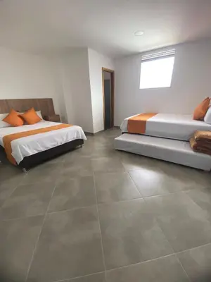 a bedroom with two beds and a tile floor at HOTEL GRAN PLAZA SAN RAFAEL in San Rafael