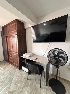 a room with a desk with a fan and a cabinet at Hermoso loft en medellin in Medellín