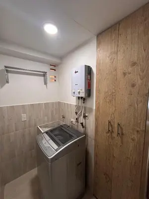 a bathroom with a trash can and a paper towel dispenser at Hermoso loft en medellin in Medellín