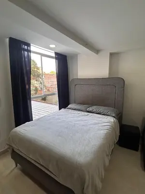 a bedroom with a bed and a large window at Hermoso loft en medellin in Medellín